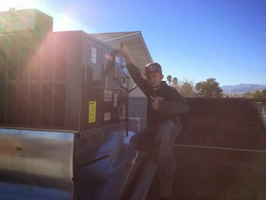 HVAC technician performing Air Duct Cleaning on a rooftop unit in Fort Polk South